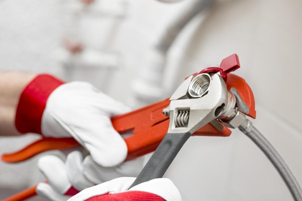 Plumber holding pipe wrenches for an emergency repair in Beaumont