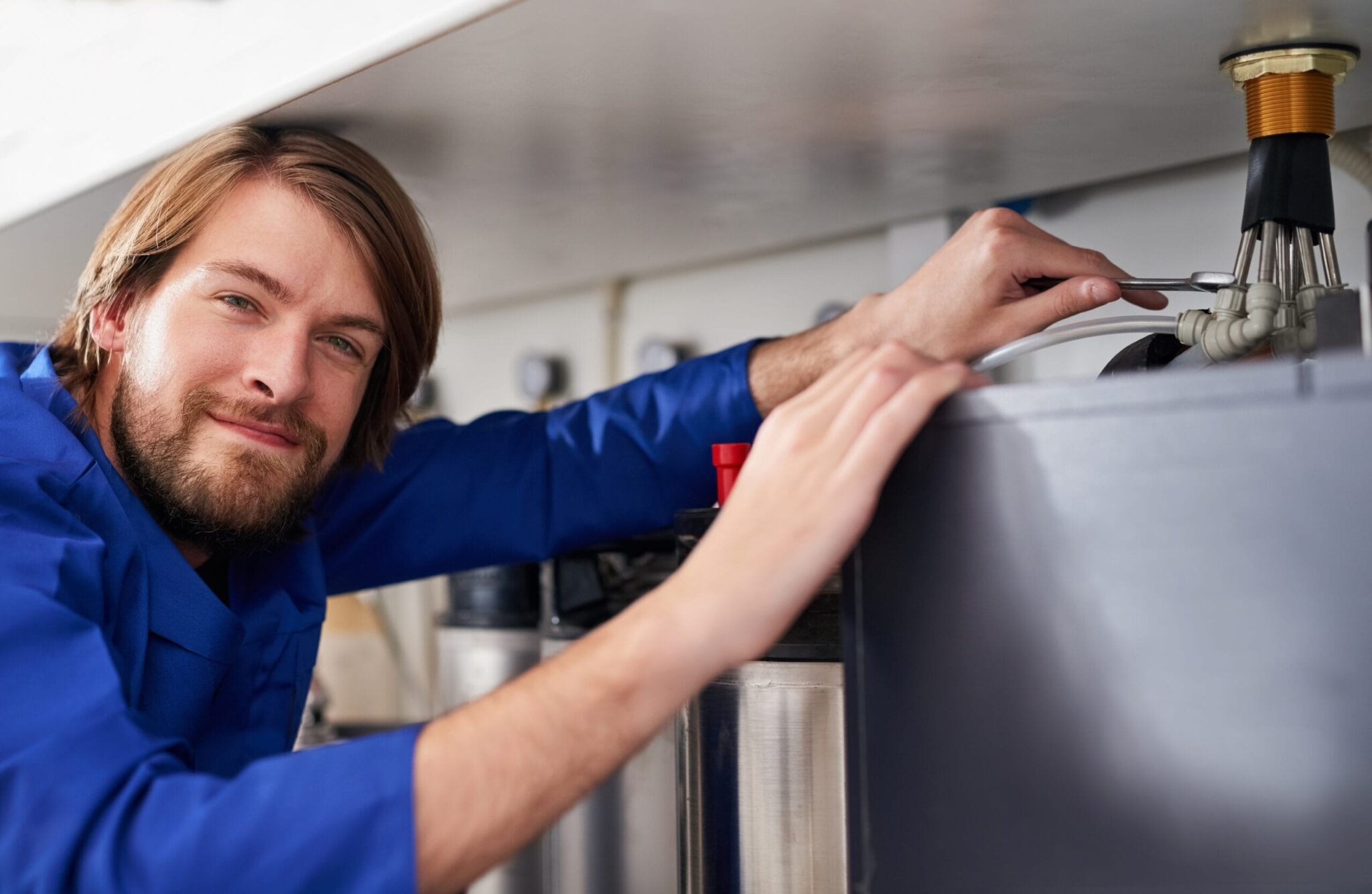 Technician servicing a residential water heater tank in Beaumont